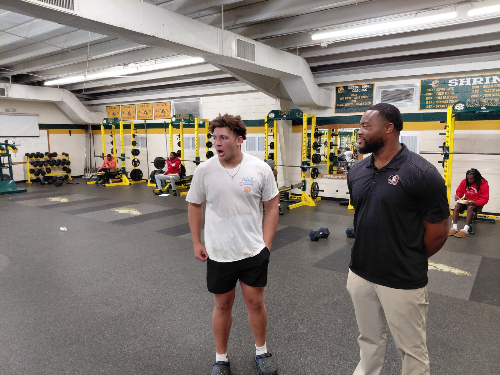 Crest football player and coach inside the weight room